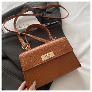 Détail du petit sac carré marron motif crocodile avec fermoir tournant doré élégant