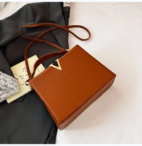 Vue détaillée du sac à main marron en cuir grainé avec boucle métallique en forme de V