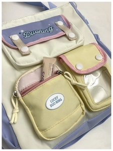 Detail of multi-pocket canvas backpack with color blocking and transparent PVC window