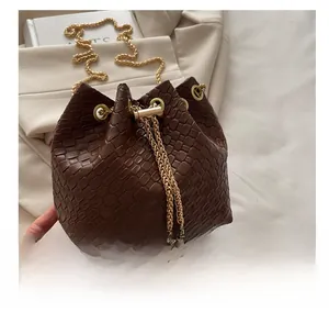 Dettaglio borsa a secchiello marrone scuro con trama intrecciata e coulisse dorata
