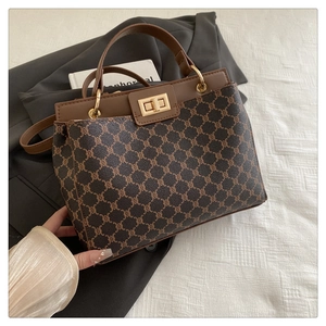Détail d'un sac seau vintage à monogramme marron avec finitions dorées et cuir