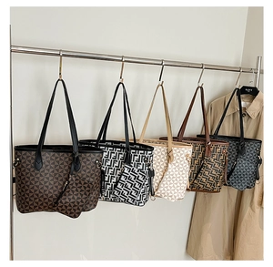 Detail view of five vintage printed tote bags with matching small zipper pouches on a rack