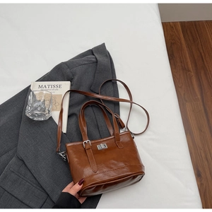 Detail of vintage brown leather handbag with silver twist lock and adjustable shoulder strap