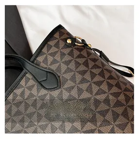 Detail of geometric pattern tote bag with leather trim and gold rivet hardware