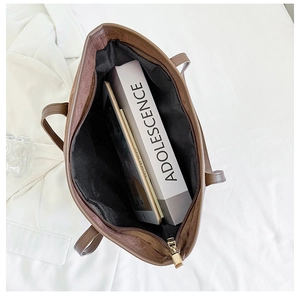 Interior view of large brown tote bag showing spacious capacity for books and tablet