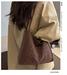 Detail of leopard print tote bag with suede texture and slender shoulder straps