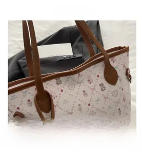 Gros plan du sac cabas imprimé montrant des motifs d'ours et des détails en cuir