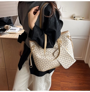 Detail showing high-capacity printed tote bag with matching zipper pouch on office desk