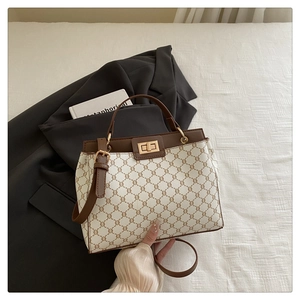 Détail du sac seau vintage avec motif monogramme et fermoir doré rotatif