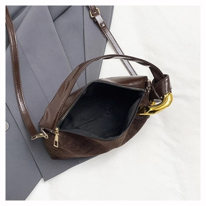 Detail view of the brown suede crossbody bag showing the zipper and inner lining