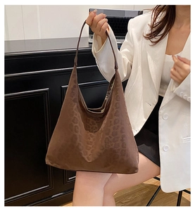 Detail of hobo shoulder bag with dark brown leopard print on white blazer model