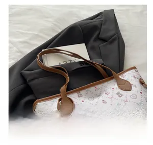 Gros plan des poignées en cuir marron avec rivets sur un grand sac cabas cartoon