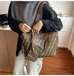 Detail of printed tote bag with matching pouch and adjustable shoulder strap on desk