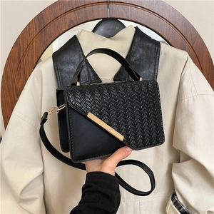Chic black crossbody bag with chevron weave texture and gold trim detail