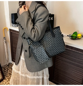 Detail of a large geometric print tote bag with a matching small zipper pouch on straps