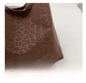 Macro detail of brown leopard print texture and high-quality stitching on a tote bag