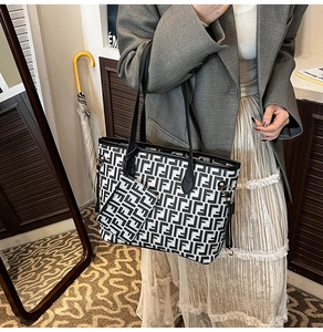 Detail of the high-capacity tote bag with black and white monogram print and a small pouch