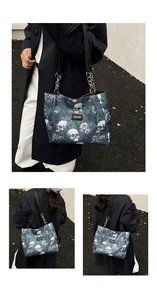 Detail of gothic floral skull tote bag featuring silver chain straps and large capacity