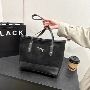 Grand sac cabas noir avec nœud doré et empiècements contrastés en cuir suédé