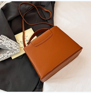 Détail d'un sac à main en cuir marron caramel avec rabat en V et poignée haute