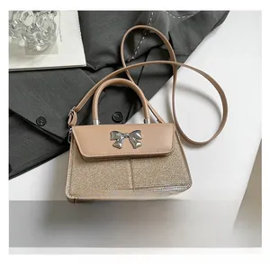 Detail of apricot sequin crossbody bag with metallic bow buckle and leather patchwork