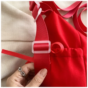 Detailaufnahme der roten bestickten Canvas-Tasche mit Nylonband und verstellbarer Schnalle