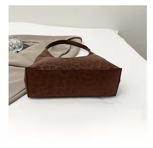 Detail shot of the wide wear-resistant bottom on this leopard print suede tote bag