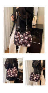Detail of floral and skull print tote bag with silver chain strap and fashion label
