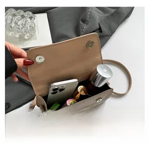 Interior view showing the capacity of a beige woven mini shoulder bag with essentials
