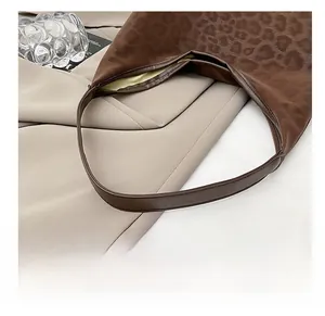 Detail showing high-quality leopard print texture and comfortable brown leather shoulder strap