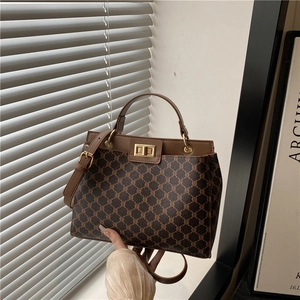 Sac seau vintage marron avec motif monogramme et fermoir doré sous lumière naturelle