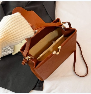 Vue intérieure d'un sac en cuir marron avec compartiment zippé et fermoir en V