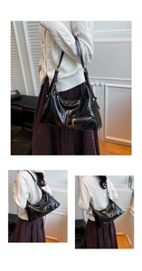 Detail of black glossy hobo bag featuring a metal zipper pocket and golden hardware