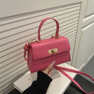 Sac à main fuchsia tissé avec boucle dorée et bandoulière dans un décor épuré