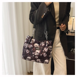 Detail of large tote bag with skull floral print and silver chain strap attachment