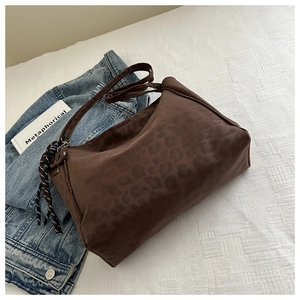Detail view of brown leopard print leather hobo bag with unique black and white knot decor