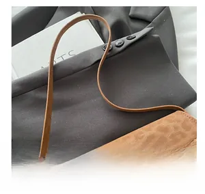 Detailansicht der braunen Wildledertasche mit goldenem Metalldrehverschluss im Vintage-Stil