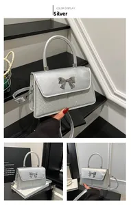 Detail view of silver bow handbag with metallic leather and sequin mesh texture