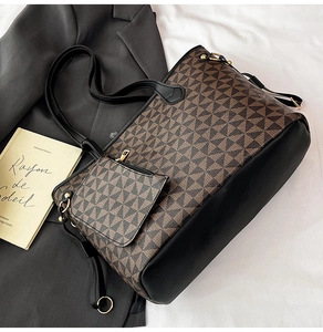 Macro view of geometric pattern print and black leather stitching on a tote bag