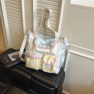 Multifunctional color-block nylon tote bag with adjustable strap on a leather bench
