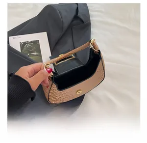 Detail of brown crocodile embossed moon bag showing spacious interior and magnetic snap closure