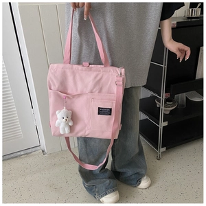 Pink canvas tote bag featuring multiple pockets, adjustable strap and plush bear charm