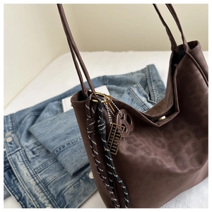 Detail of leopard print tote bag featuring a retro abacus charm and magnetic closure