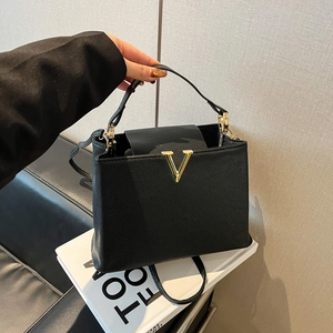 Sac à main trapèze noir élégant avec boucle en V dorée et texture grain lychee
