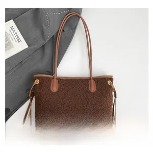 Detail of brown plush tote bag with lamb wool texture and sleek faux leather straps