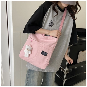 Detail of pink canvas tote with bear charm and Fashion Instinct label on strap