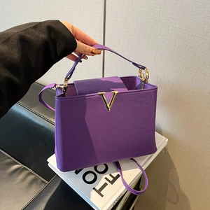Sac à main élégant en cuir violet avec boucle en V dorée et bandoulière amovible