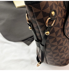 Detail of vintage geometric print tote bag with gold rivets and black leather trim