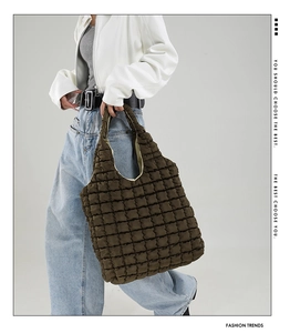 Quilted oversized puffy tote bag in deep brown featuring soft padded fabric texture