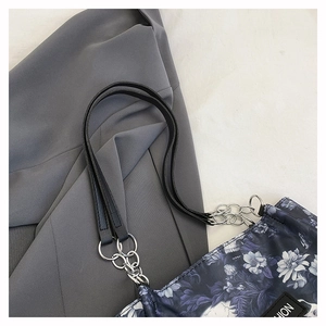 Detail of floral tote bag with leather straps and silver metal chain connection